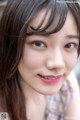 A close up of a woman with long brown hair.