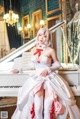 A woman in a white dress sitting on a white piano.